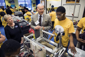 Detroit Superintendent Nikolai Vitti and Jeanne Murabito speak with students as they work on a robot at the Michigan Engineering Zone.